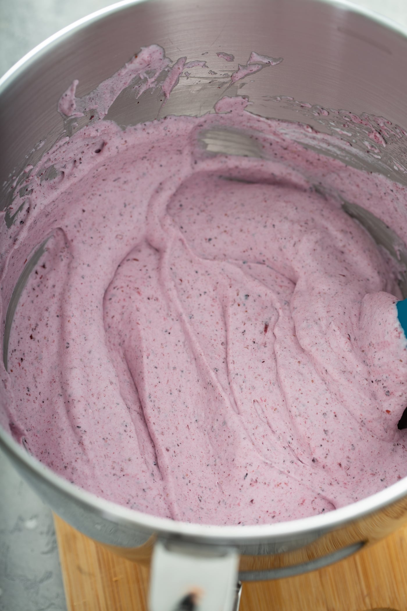 A pan filled with pureed berries mixed with whipped cream. It is a whipped pink filling with bits of pureed berries.