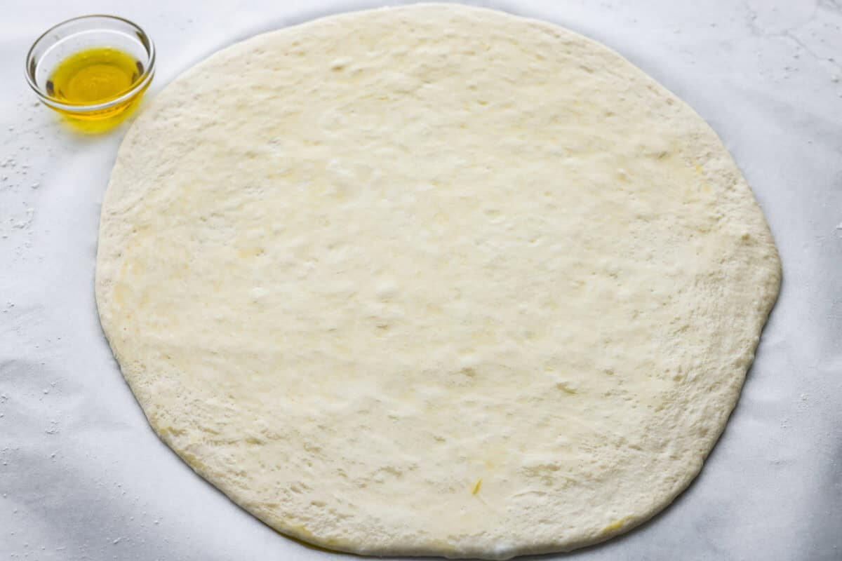 Pizza dough rolled out into a circle.