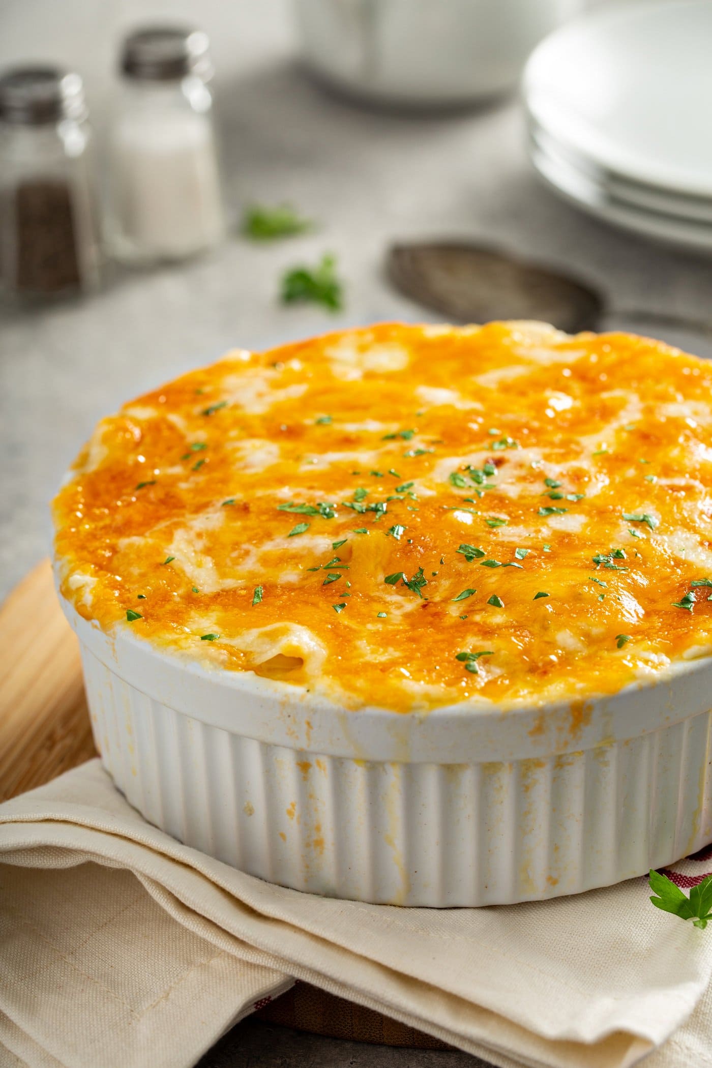 A casserole dish full of cheesy potatoes. The cheese is melted and toasted.