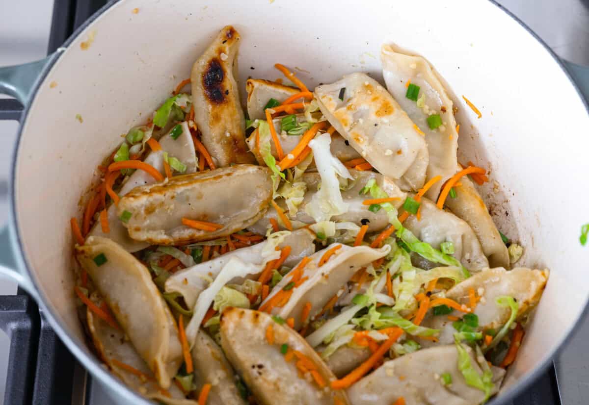 Veggies added to the potstisckers to cook.