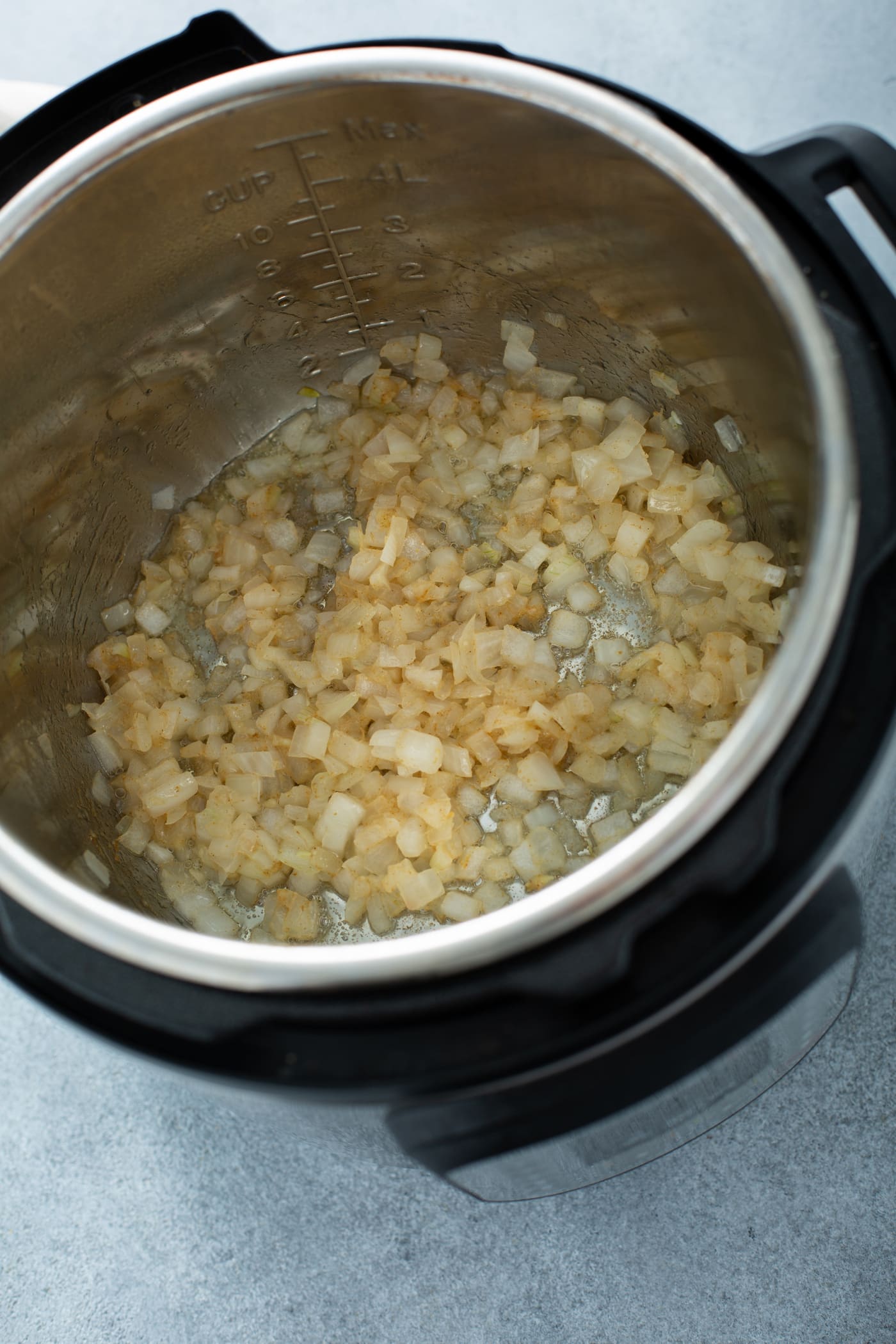 A photo of chopped onions being sauteed in an Instant Pot.