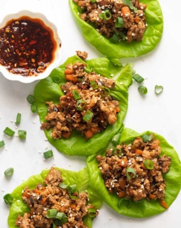 Overhead picture of chicken lettuce wraps with sweet chilli sauce on the side