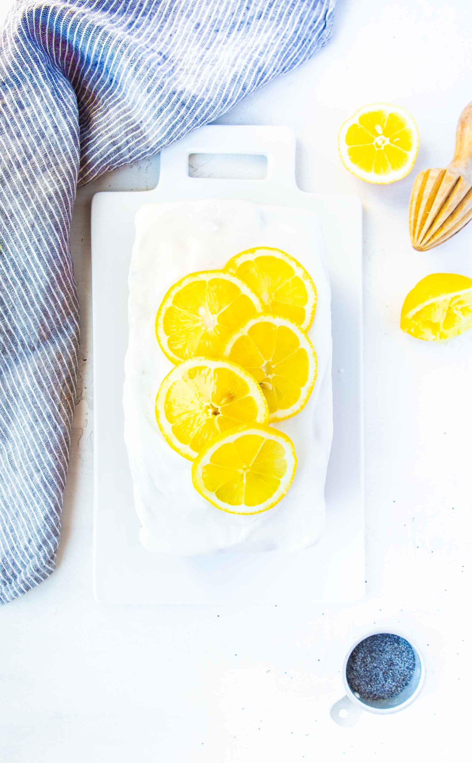 a photo taken directly above a lemon loaf cake topped with bright white icing and thinly sliced lemons.