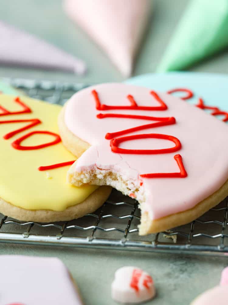 A close up on the sugar cookie with a bite taken out of it.