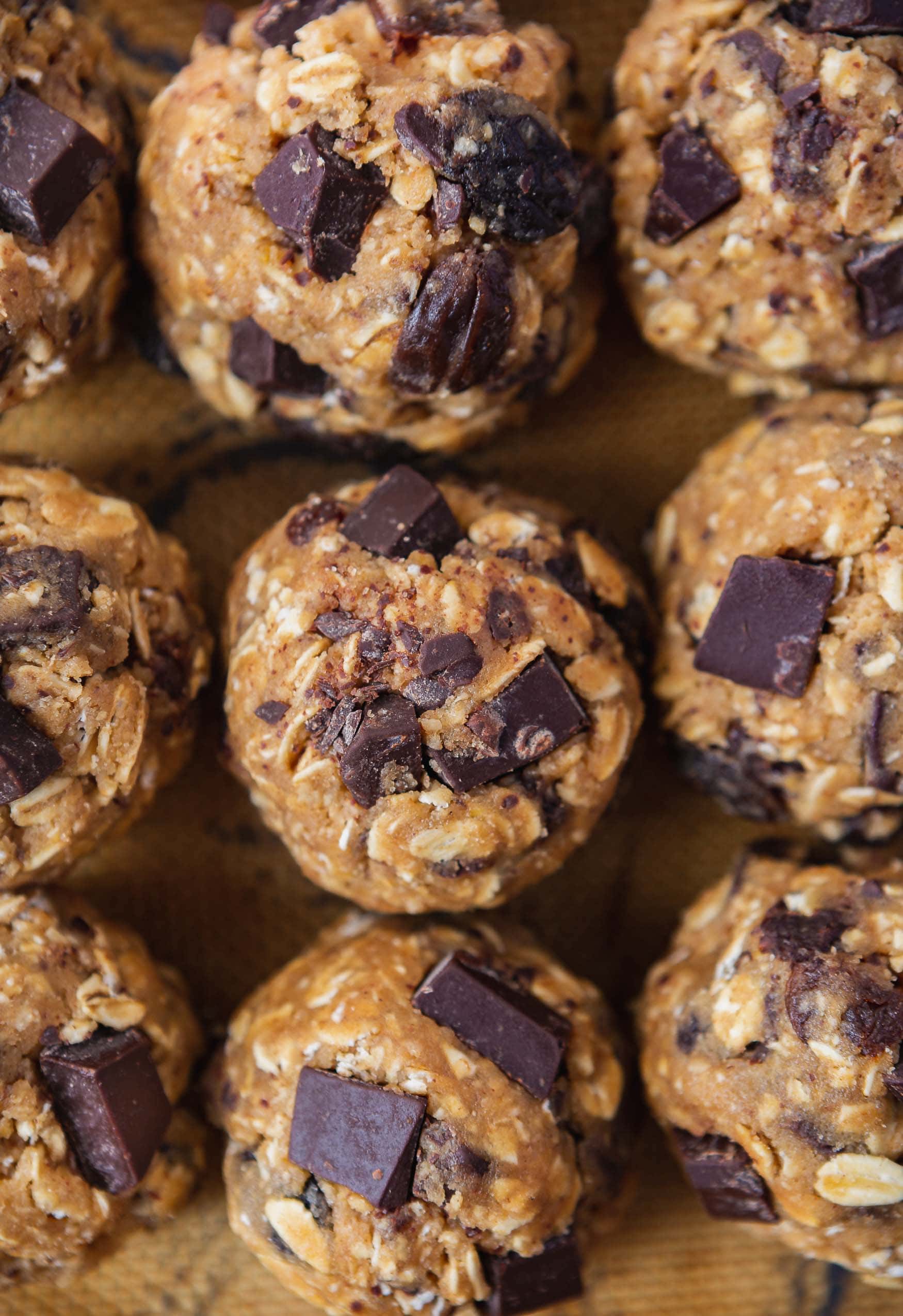 A plate of oatmeal raisin chocolate chip cookies. You can see chunks of chocolate in the cookies.