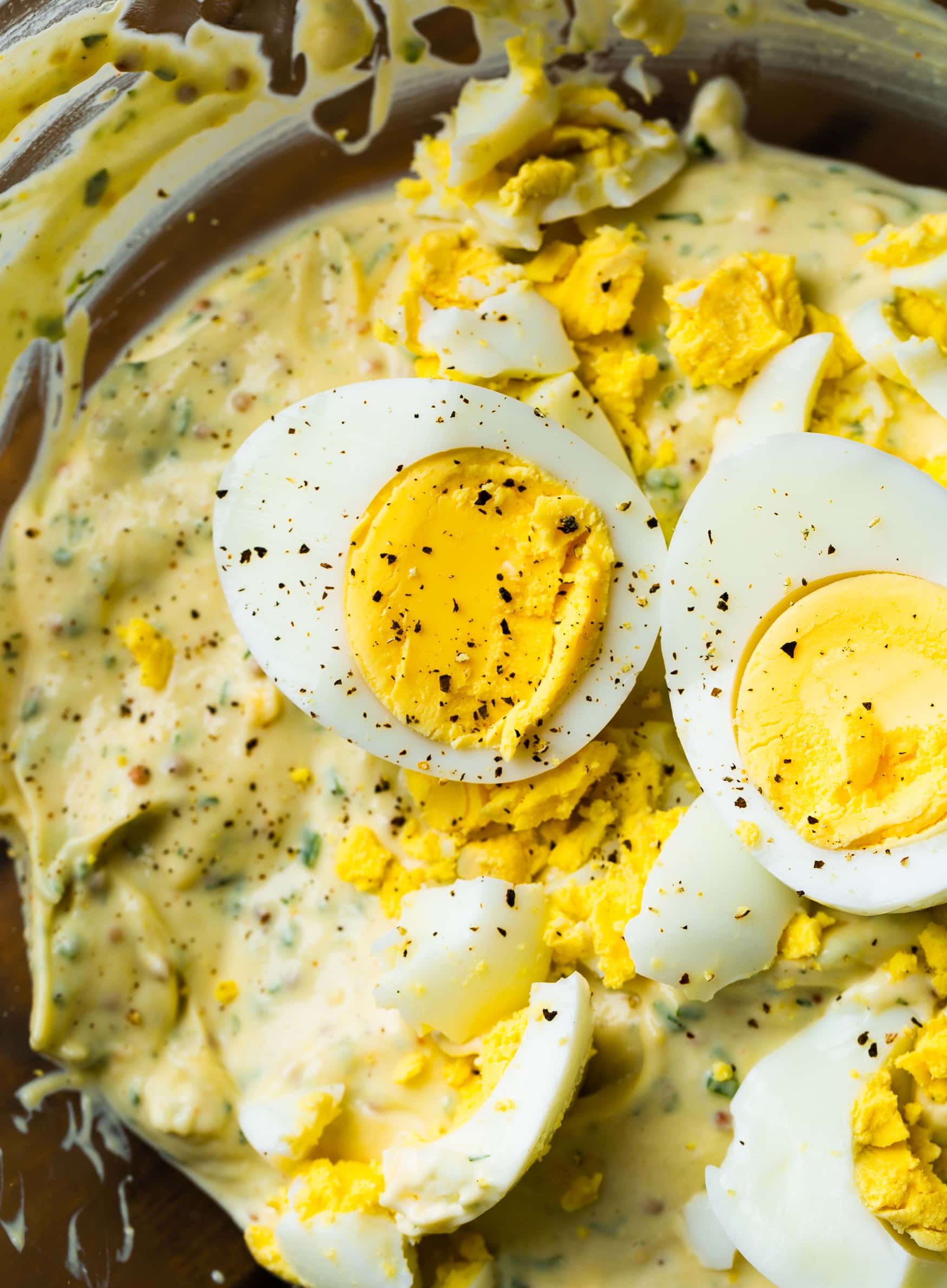a photo of hard boiled eggs that have been halved with the yolks showing that have been topped with pepper.