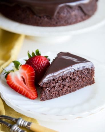 A slice of chocolate cake on a plate with strawberries