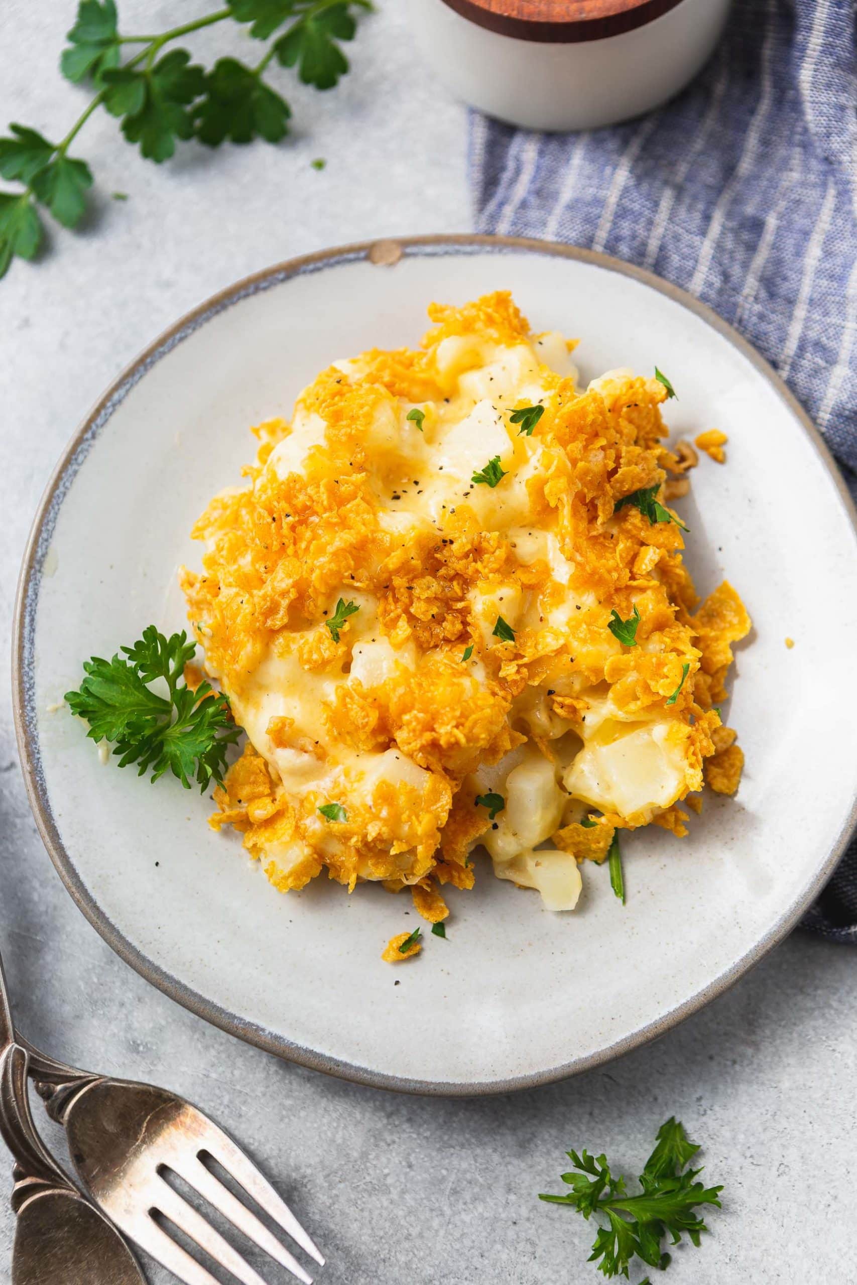 A photo of a plate of cheesy potato casserole topped with golden crunchy topping.