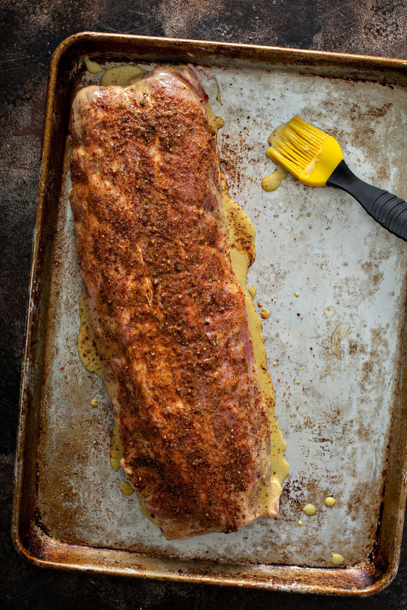 A rack of ribs covered with bbq rub and ready to go on the grill.