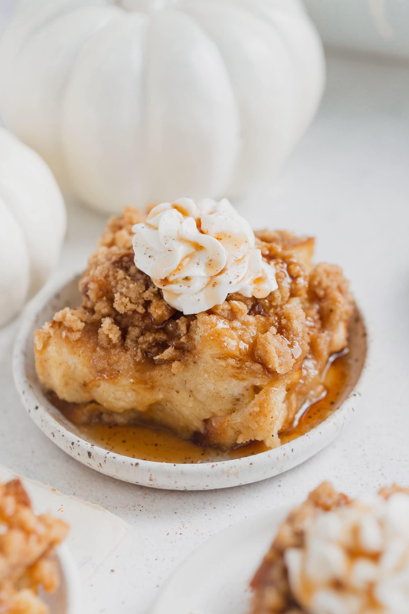 A serving of eggnog french toast casserole. The french toast is topped with whipped cream.