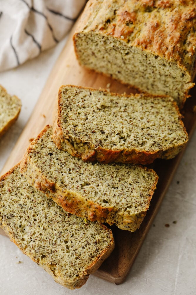 A loaf of keto bread that is sliced on a cutting board. 