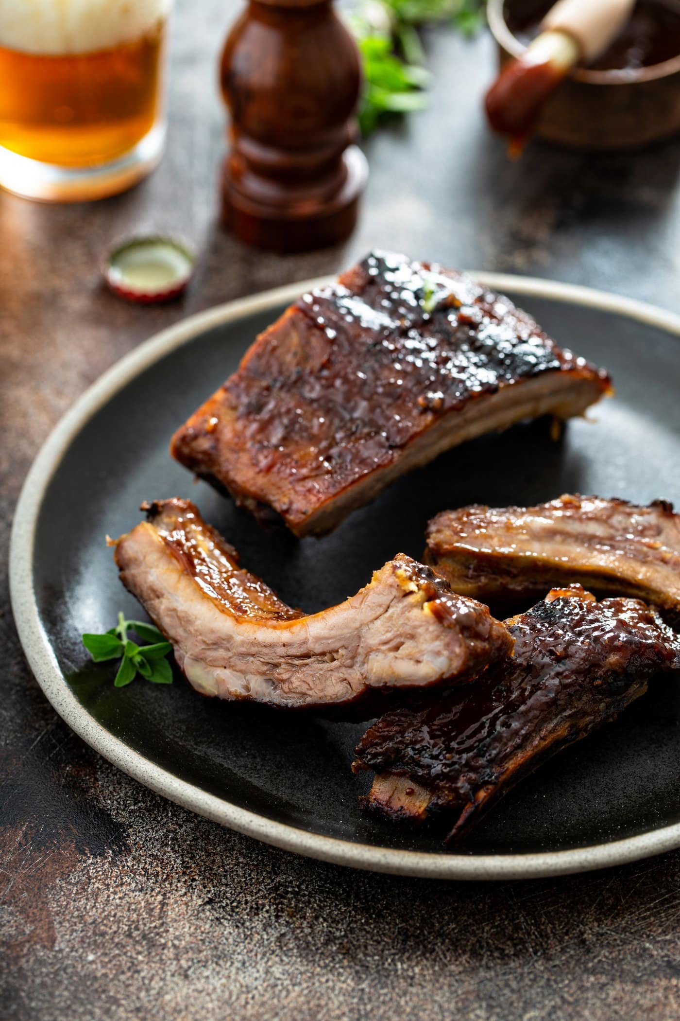 A dinner plate with several grilled pork ribs.