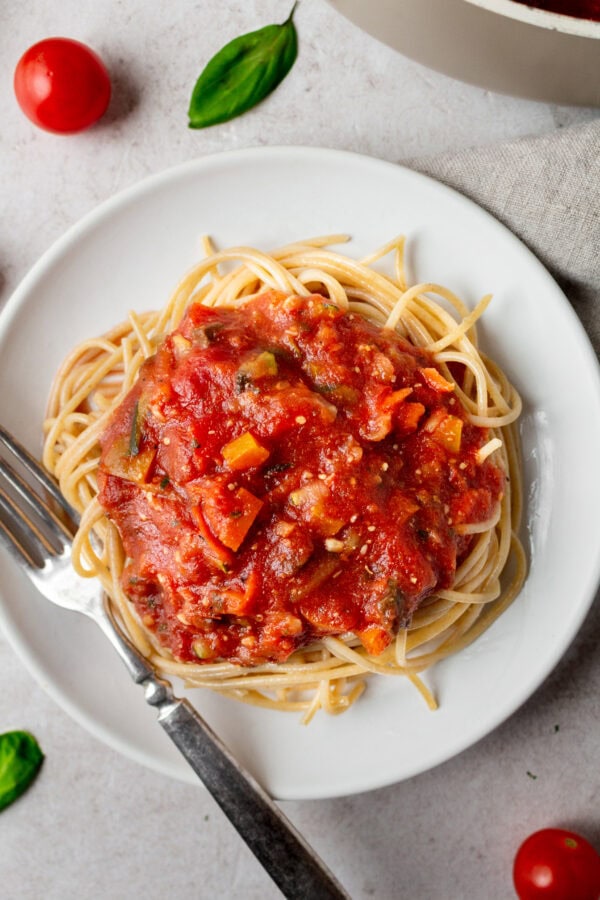 a photo of vegetable marinara on top of cooked angel hair pasta