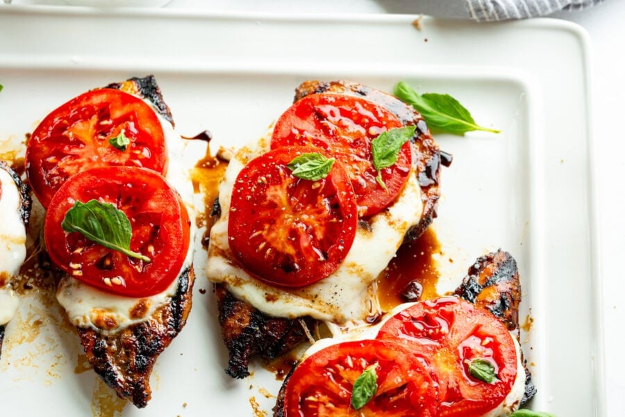 several grilled chicken breasts topped with melted fresh mozzarella, sliced tomatoes, fresh basil and a balsamic glaze - chicken caprese