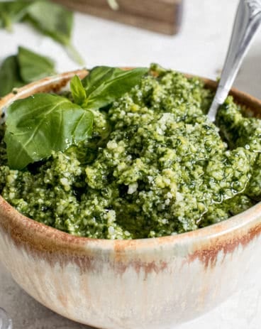 best basil pesto in pottery bowl with silver serving spoon