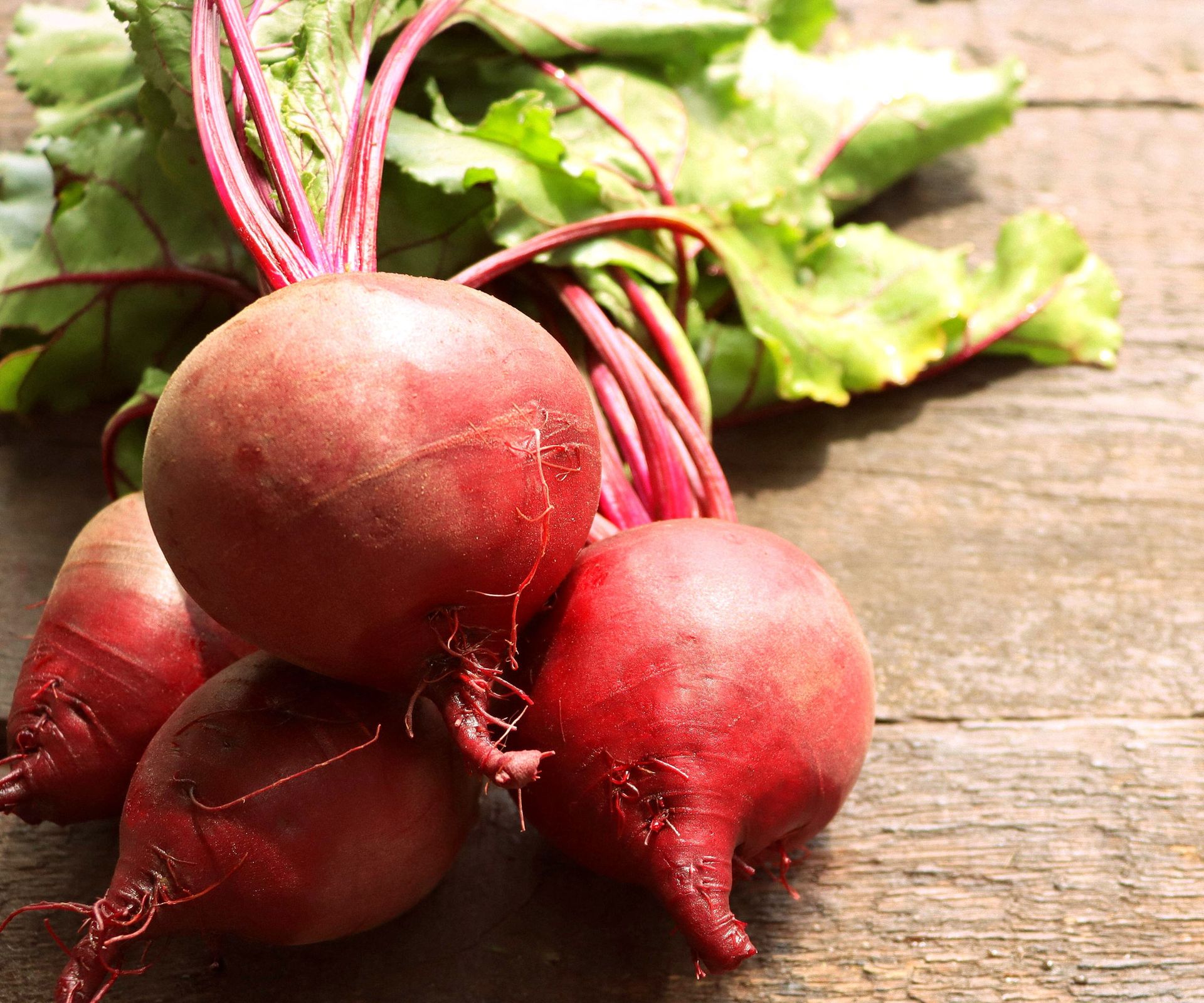 red baby beets lying on wooden table