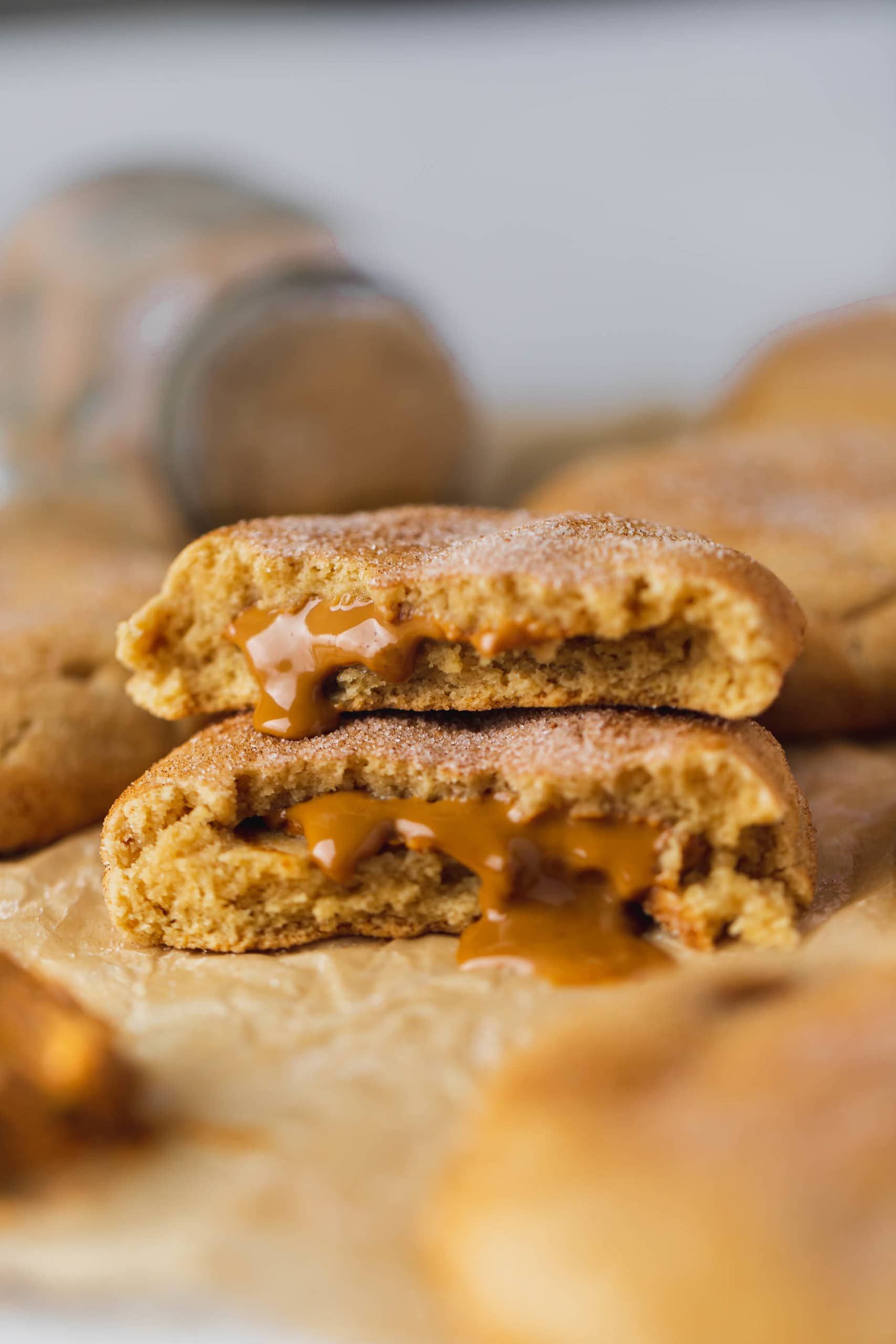 A biscoff stuffed snickerdoodle that is broken in half and the halves are stacked on top of each other. You can see the biscoff center.