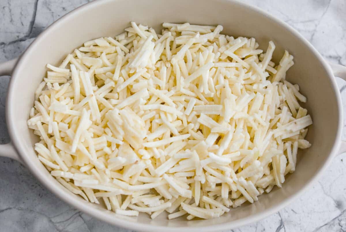 Hash browns in the bottom of a baking dish. 