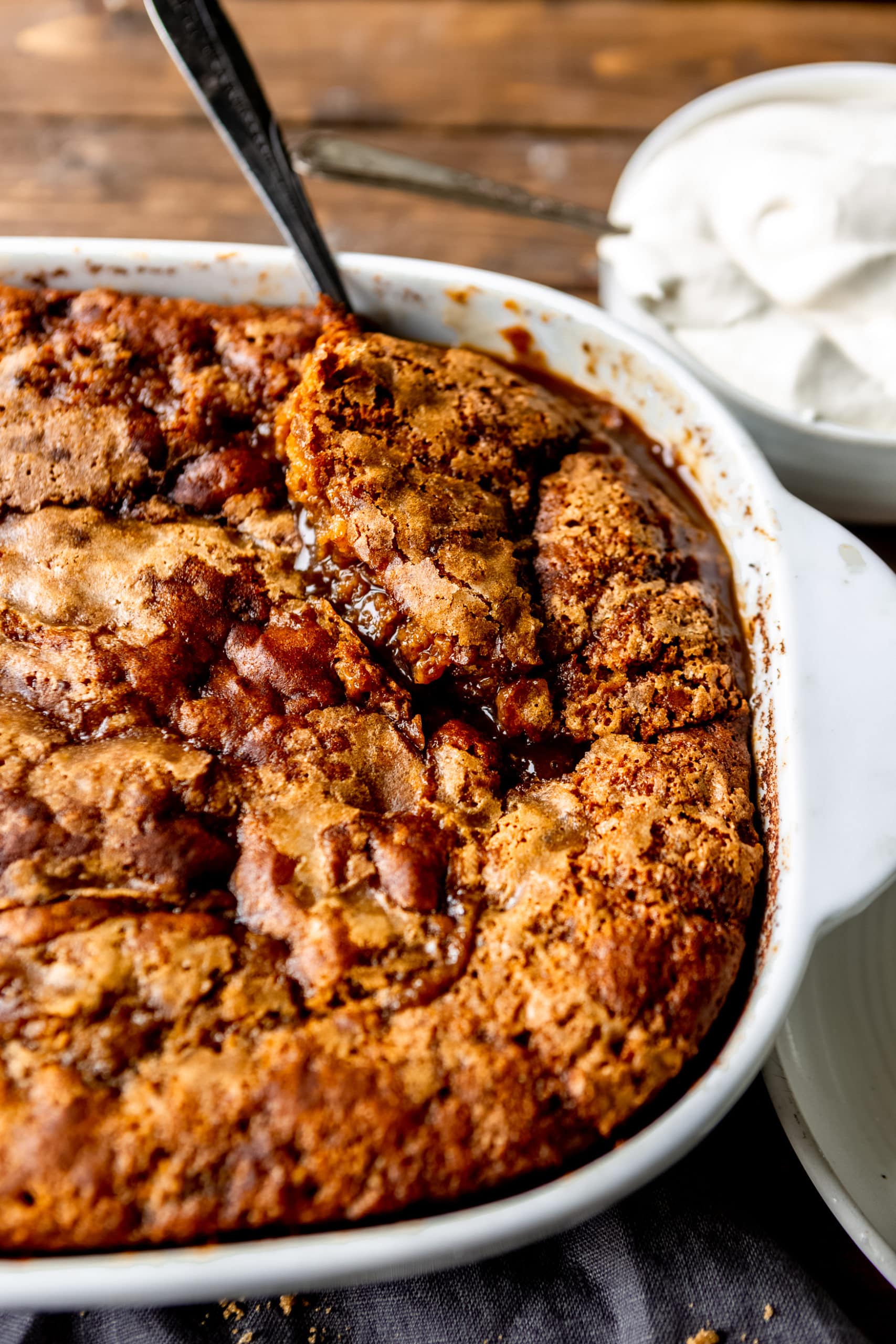a photo of a white ceramic baking dish full of a baked pumpkin lava cake.