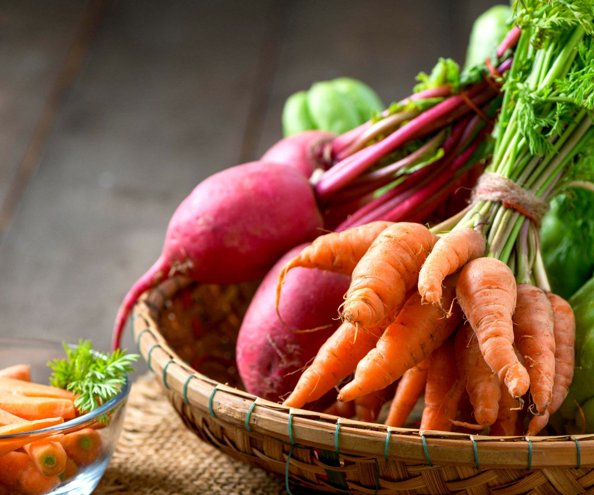 baby carrots and beetroot harvest in wicker basket on wooden table