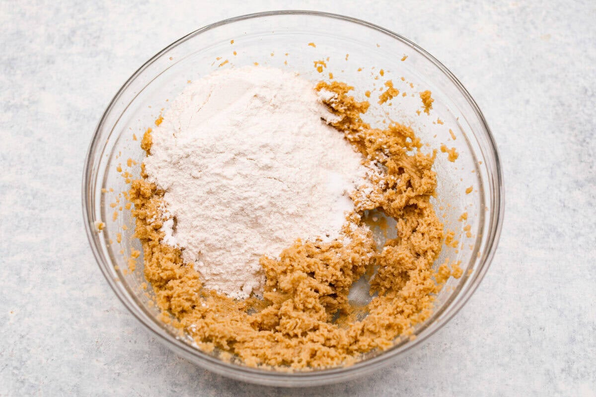 Overhead shot of a bowl with some mixed ingredients and flour. 