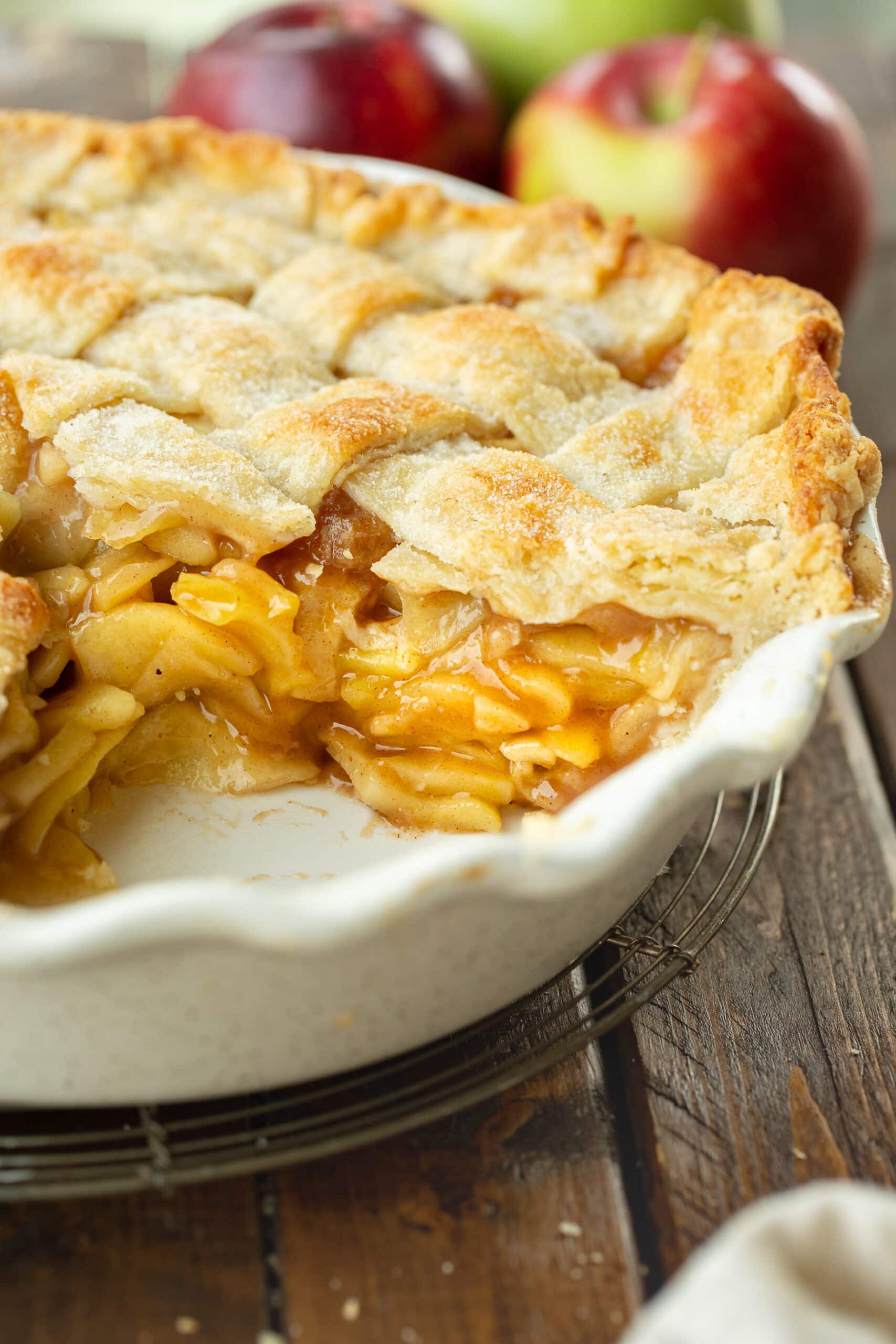 a photo of the cross section of a whole apple pie where a piece of pie has been removed from the pie dish so you can see the perfect pie filling.