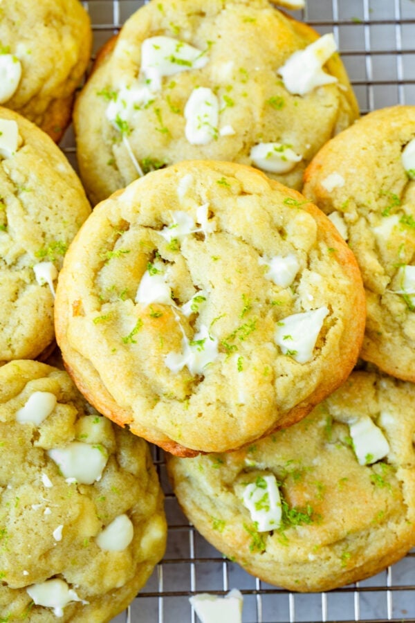 a photo of several golden baked cookies loaded with white chocolate chunks and lime zest.