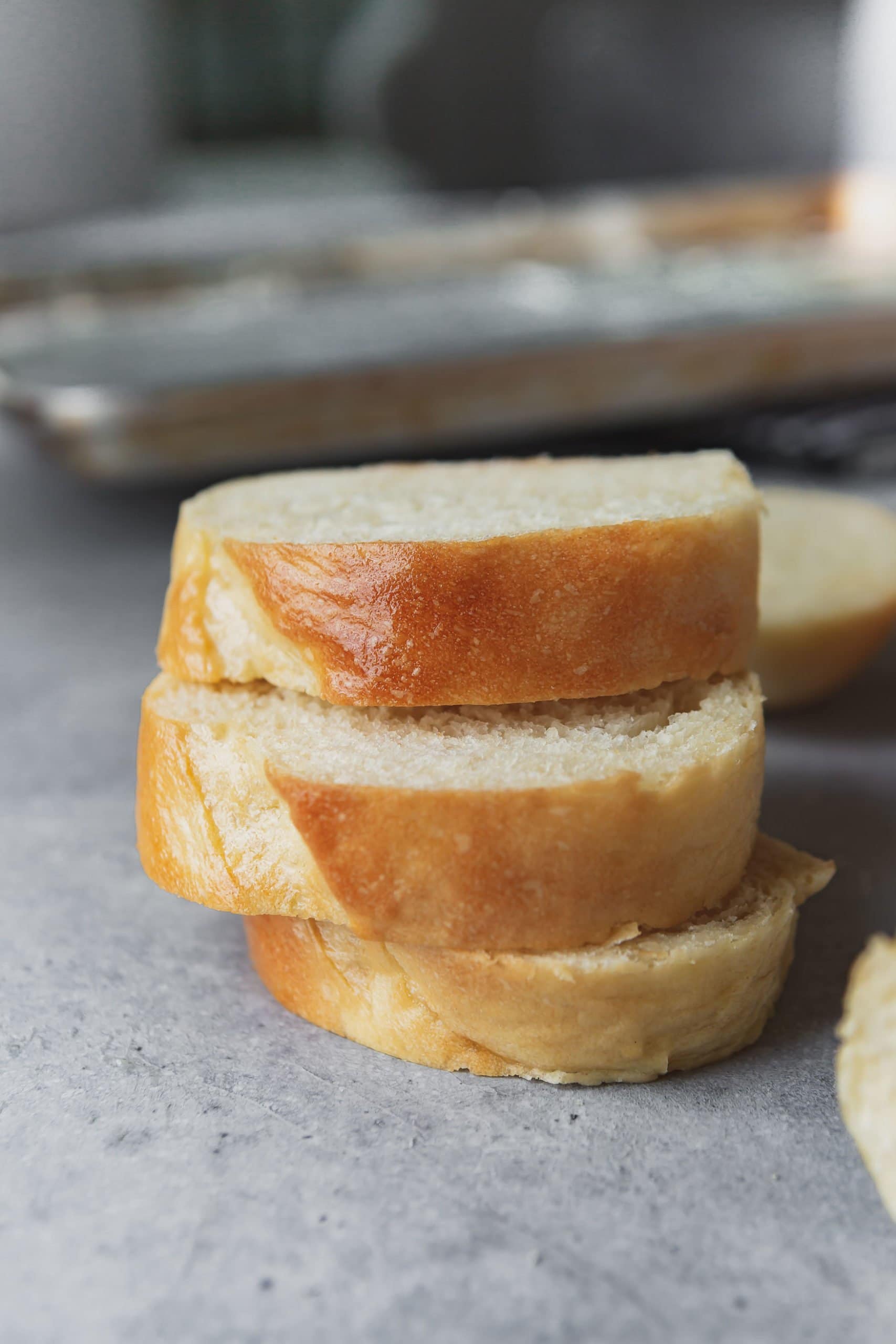 a photo of three slices of french bread stacked on top of each other with the buttery golden top facing the camera.. a photo of three slices of french bread stacked on top of each other with the buttery golden top facing the camera..