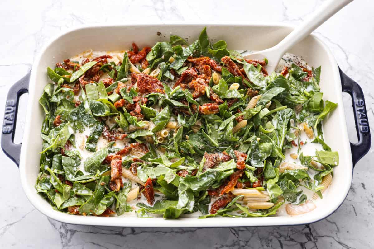 Someone stirring all of the ingredients in the baking dish. 