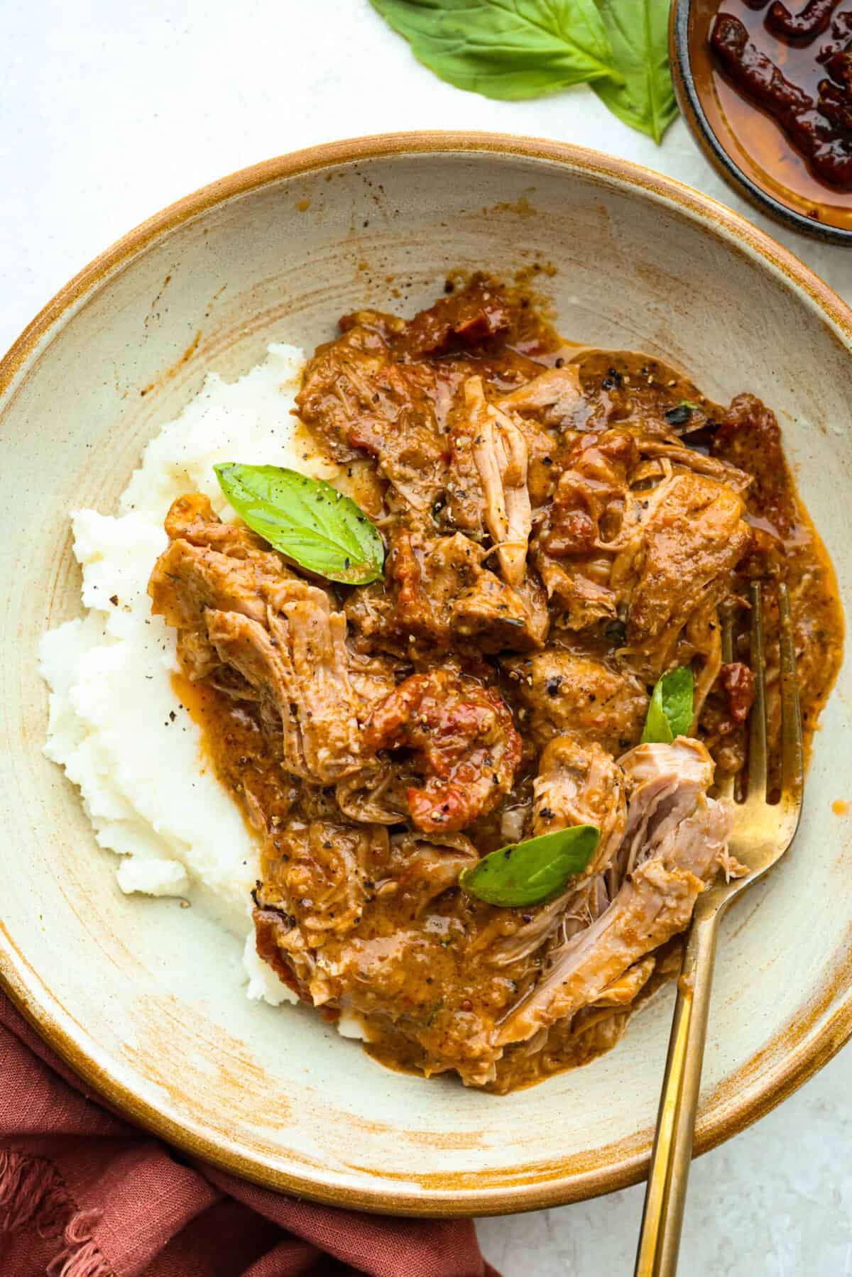 Plate with Marry Me Pork roast serving over mashed potatoes and a gold fork.