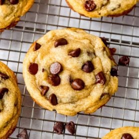 Baked chocolate chip cookies on a cooling rack.