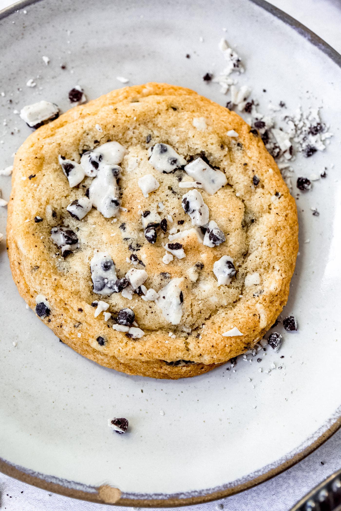 A large cookies and cream cookie. The cookie is loaded with bits of cookies and cream candy bar.