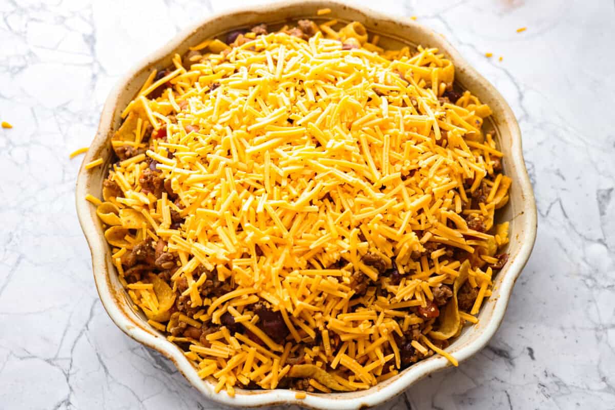 Cheese added to the top of the Frito Chili pie ready to go in the oven. 