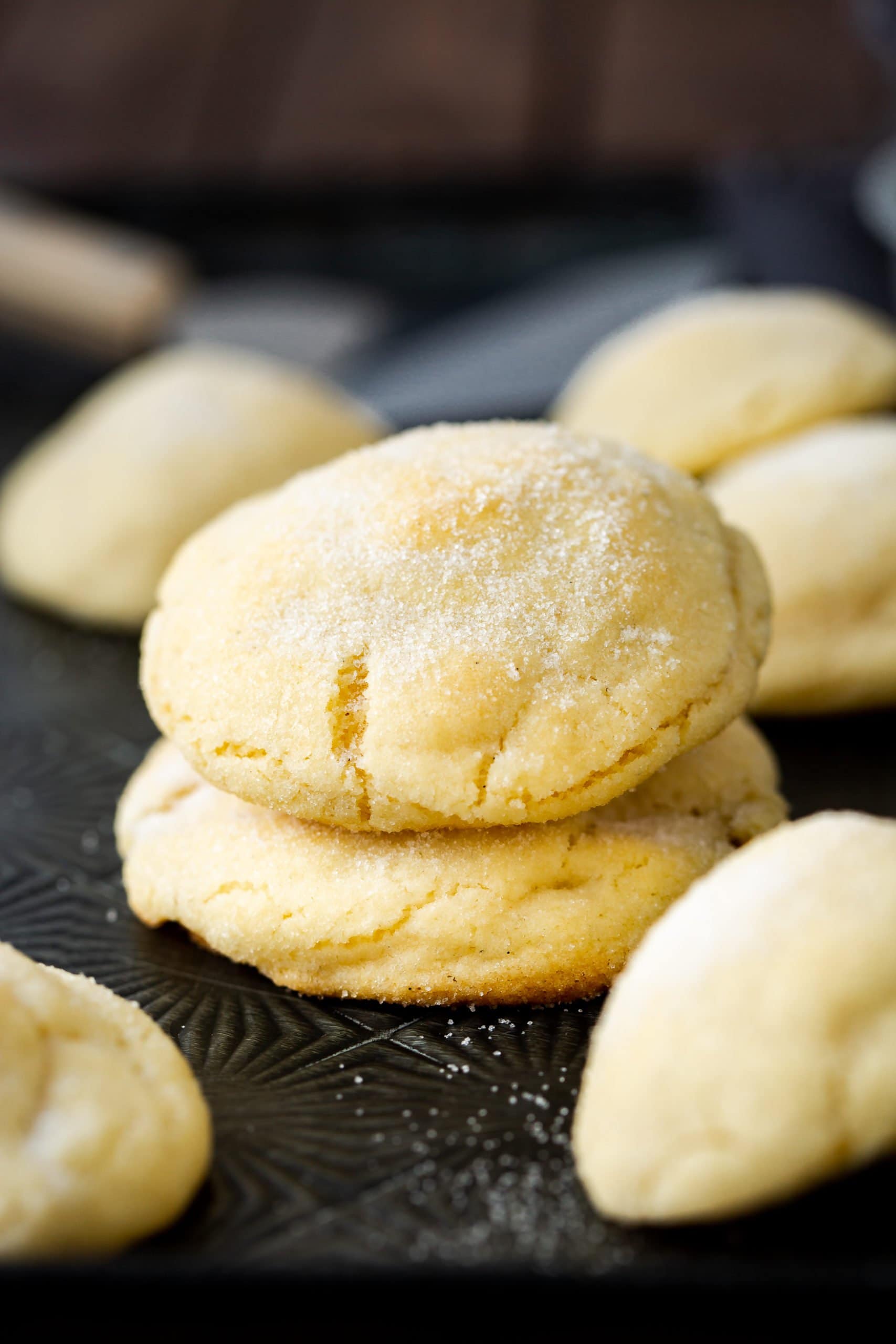 a photo of two think and perfectly golden sugar cookies stacked on top of each other. the cookies are coated in white sugar.
