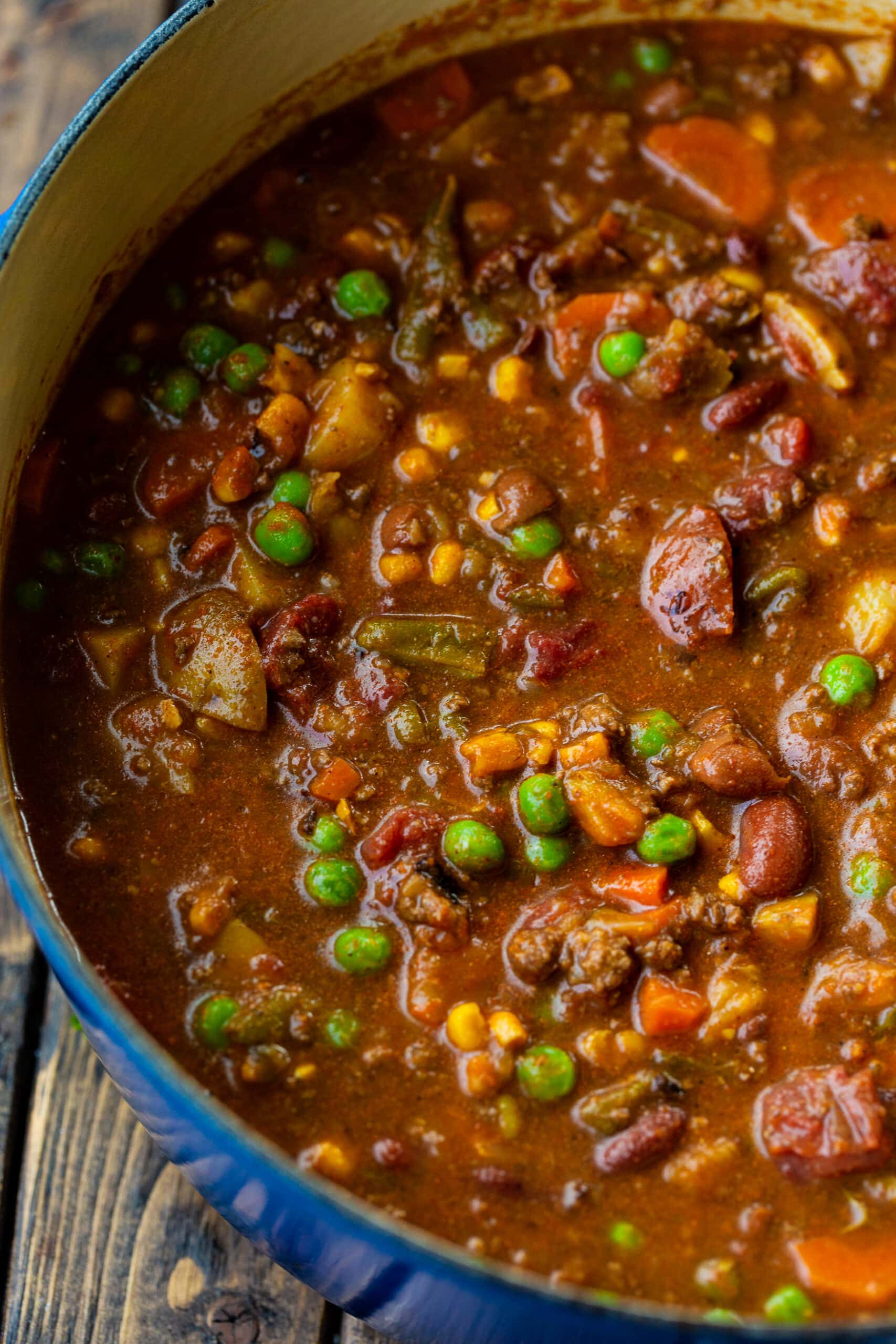 a photo of a dutch oven full of taco stew including peas, carrots, potatoes, and ground beef. a photo of a dutch oven full of taco stew including peas, carrots, potatoes, and ground beef.