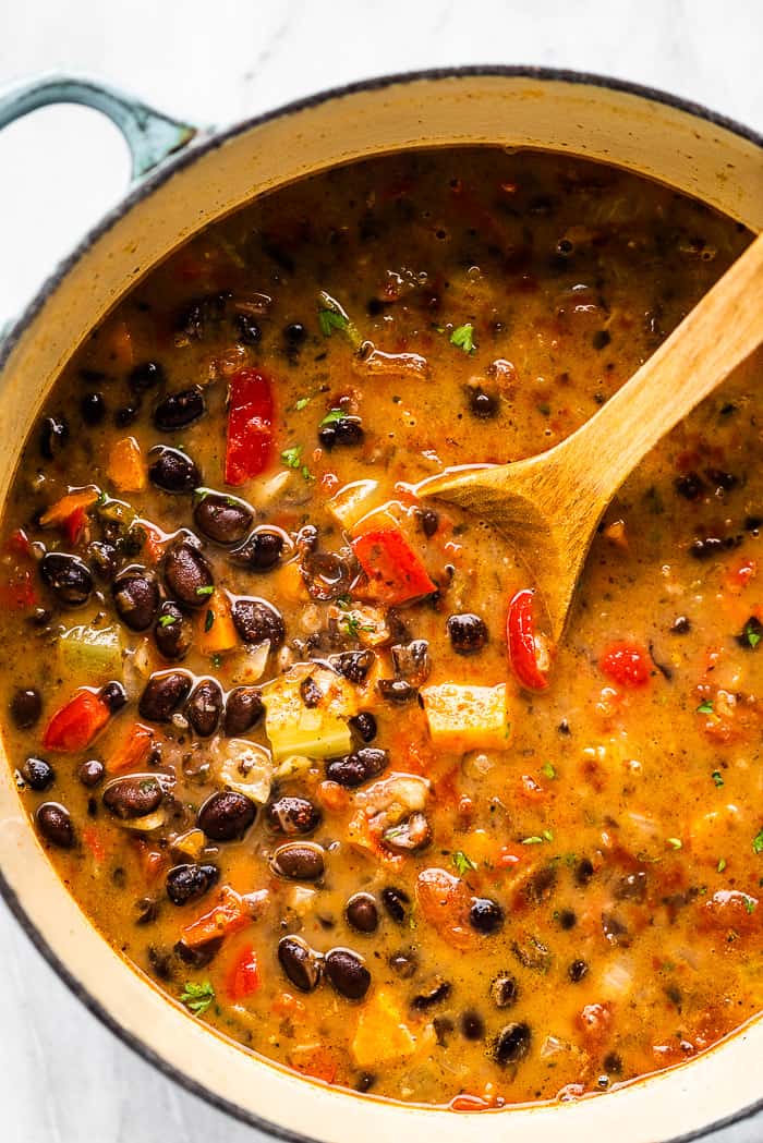 A pot of black bean soup with a wooden spoon. A pot of black bean soup with a wooden spoon.