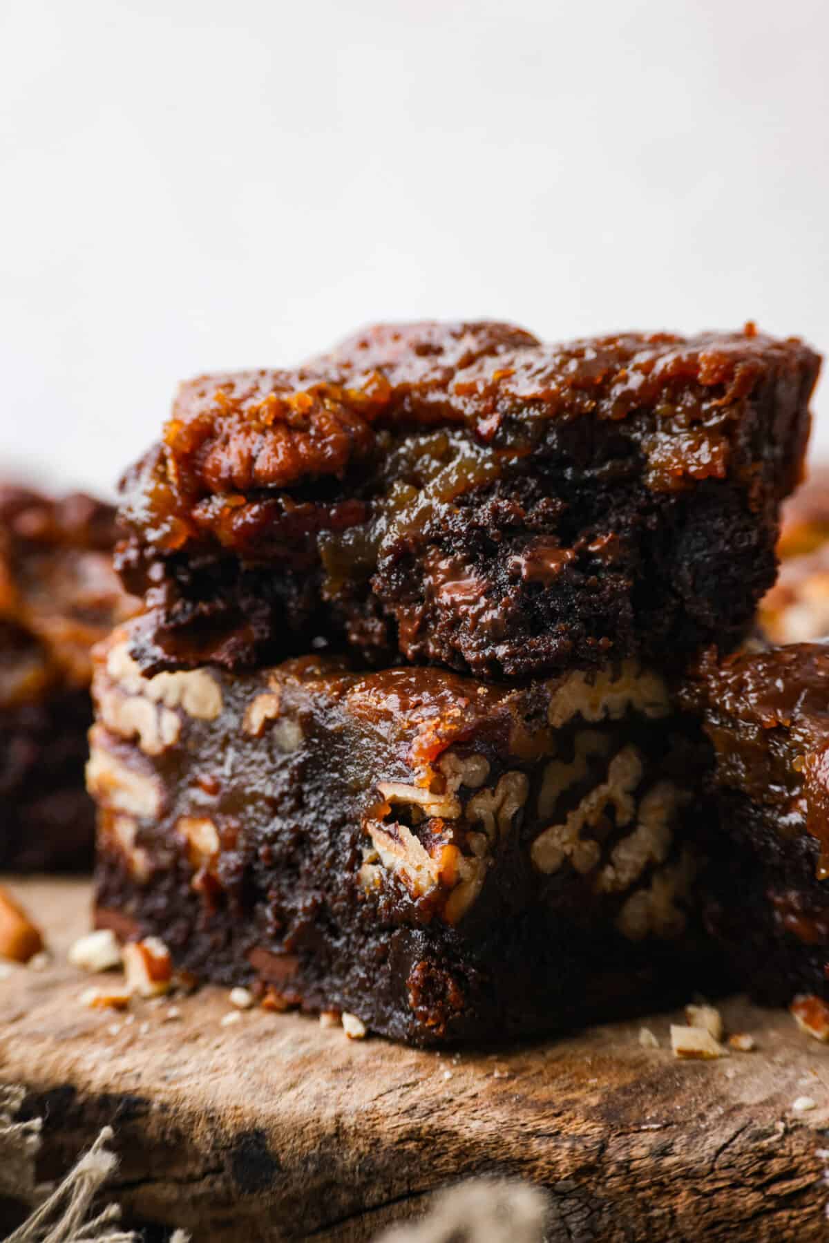Closeup of pecan pie brownies, one with a bite taken out of it.
