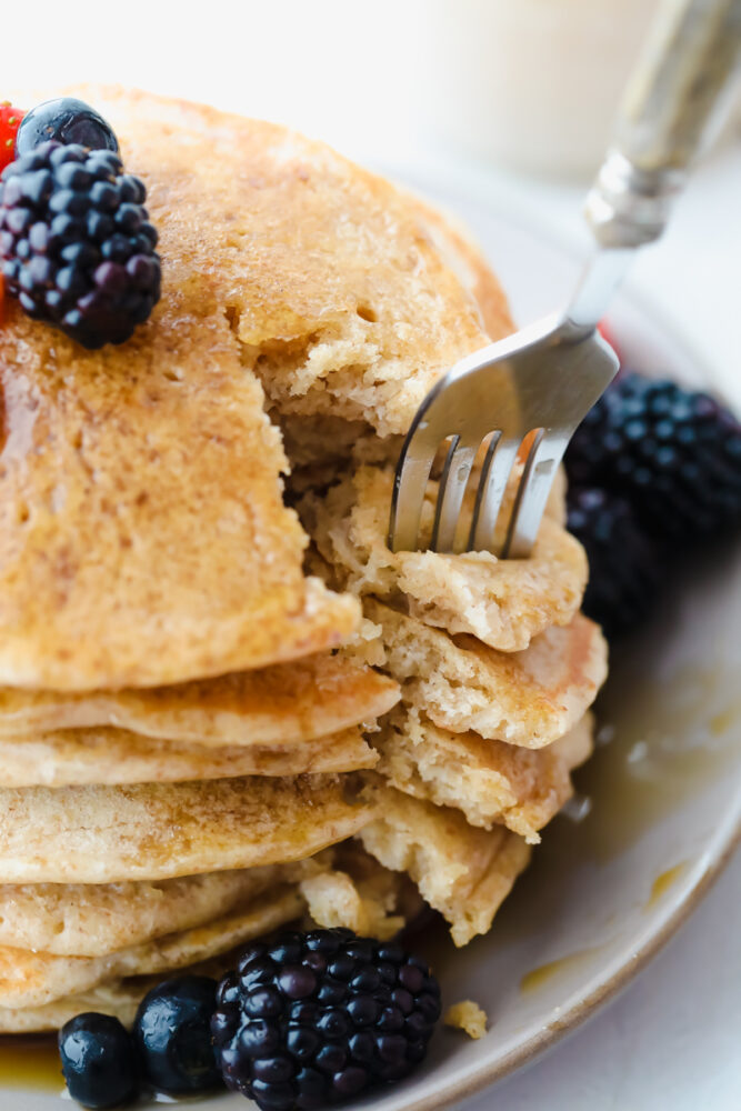 Cutting a slice of sourdough pancakes with a fork. 