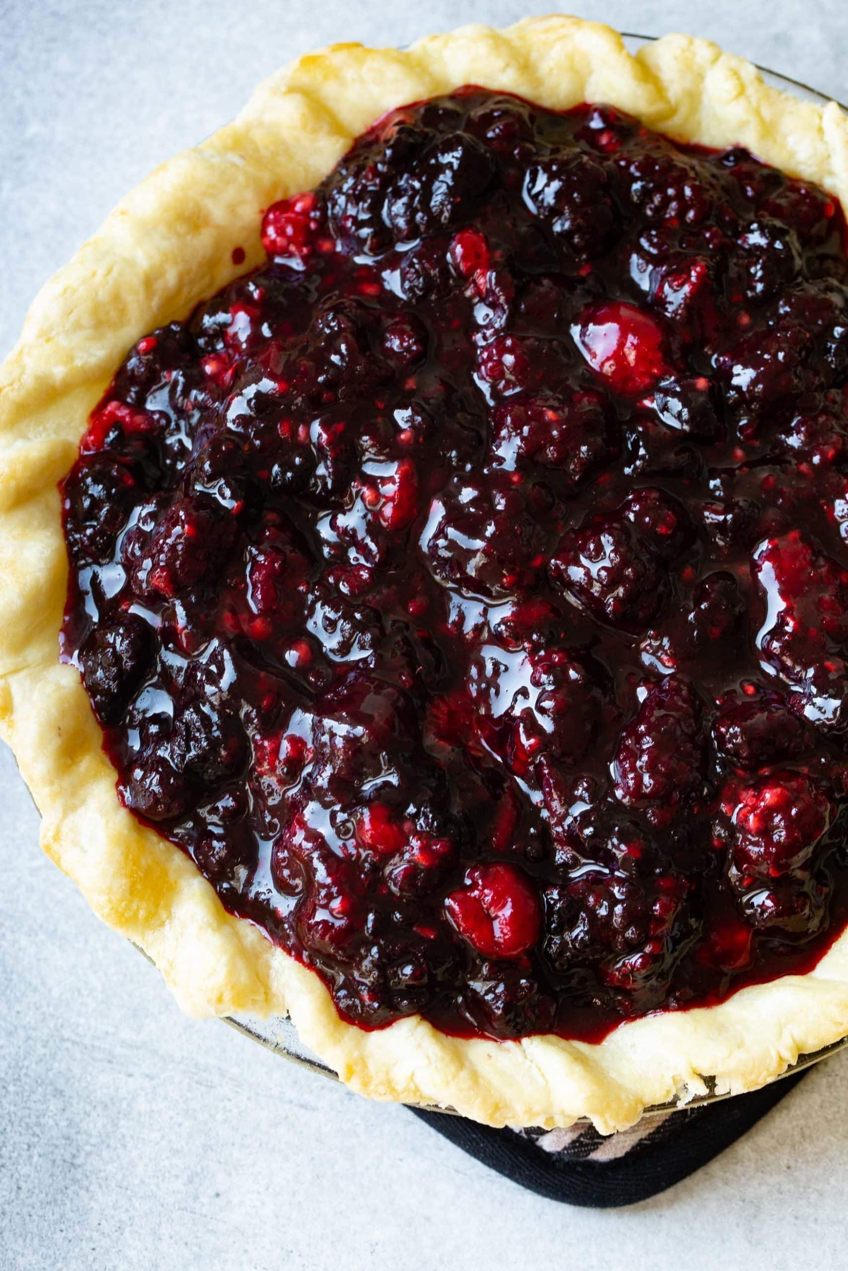 a photo of a whole unbaked mixed berry pie with a homemade crust ready to go into the oven.