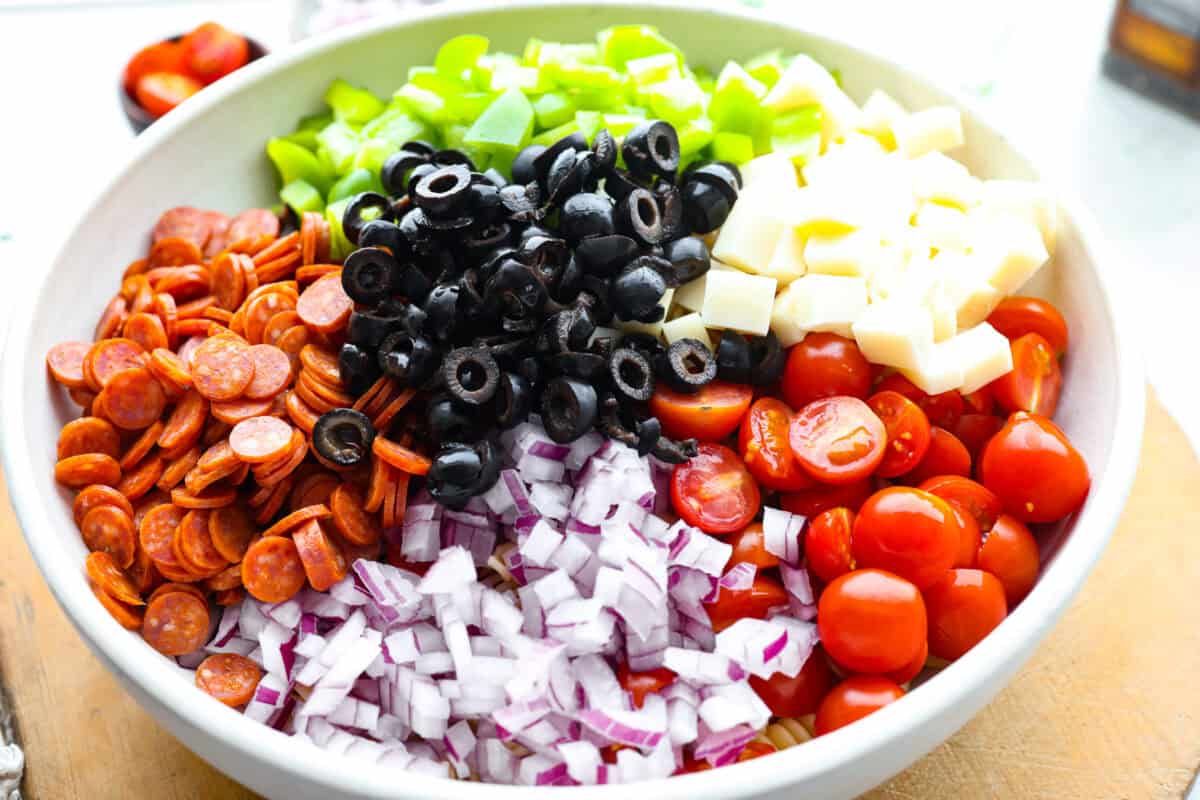 Chopped salad ingredients added to a bowl. 