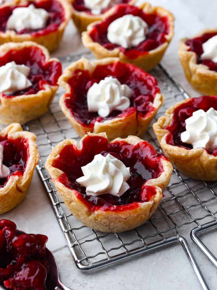 Mini cherry pies on a cooling rack. 
