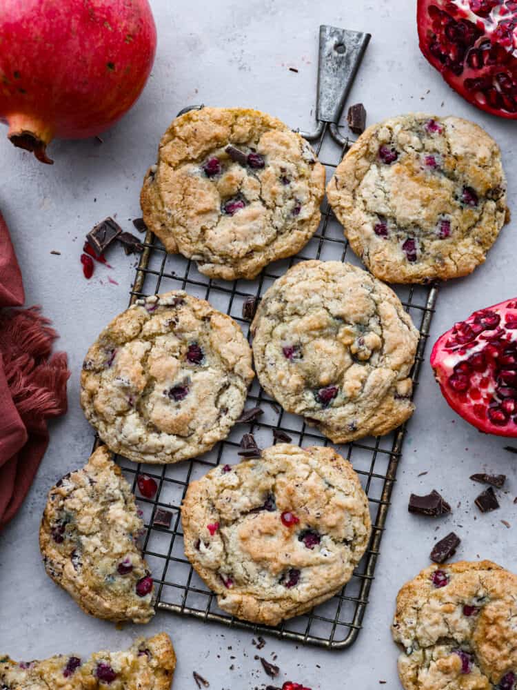An overhead view of the cookies on a wire rack with pomegranate around it.