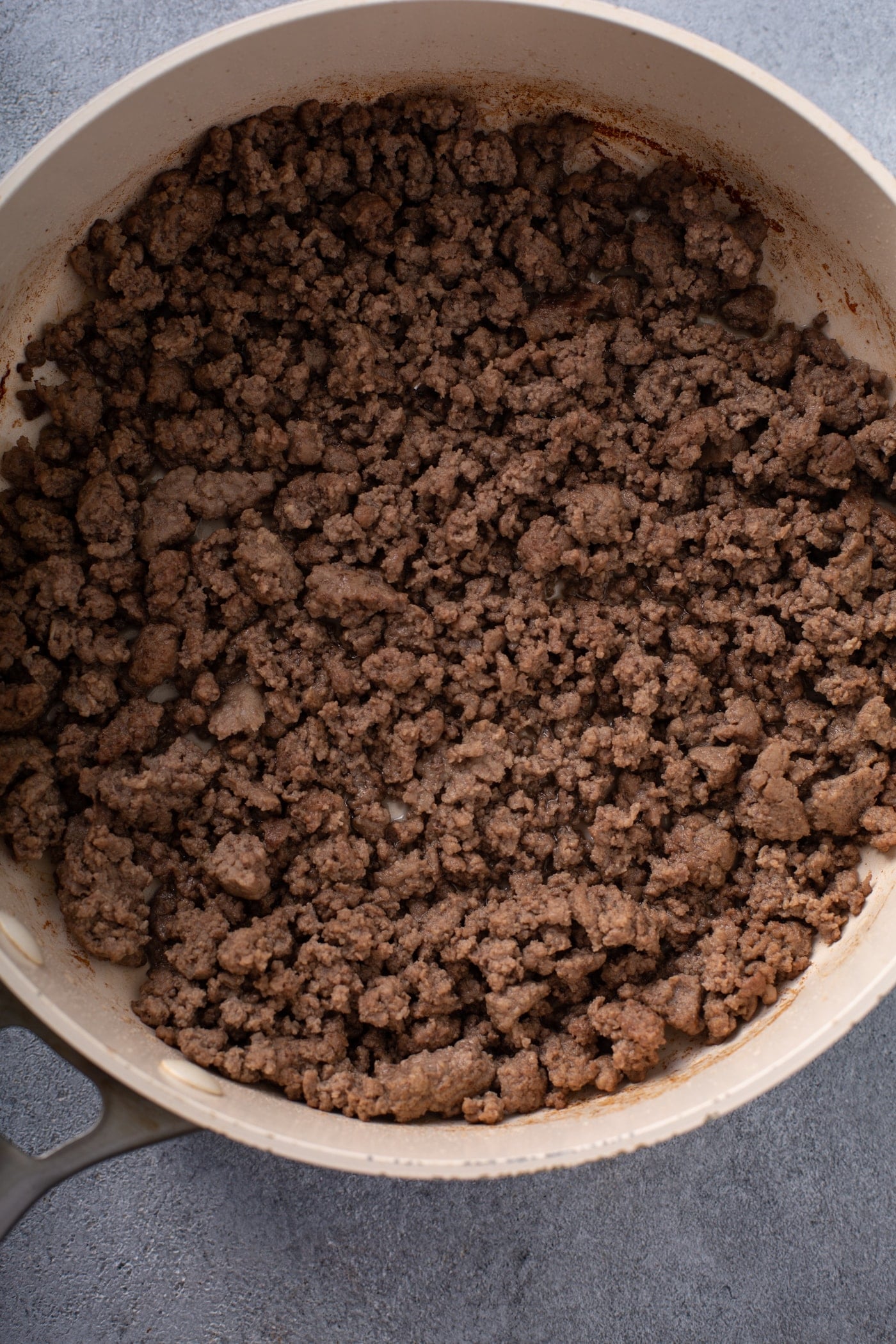 A casserole dish containing browned ground beef.