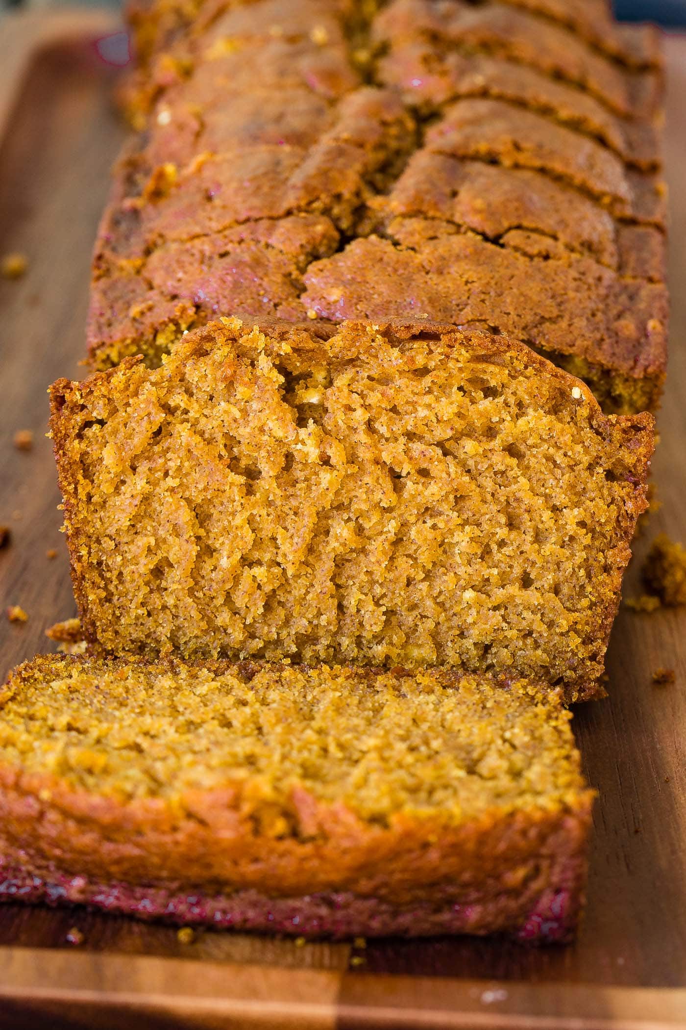 a sliced load of pumpkin bread on a wooden platter
