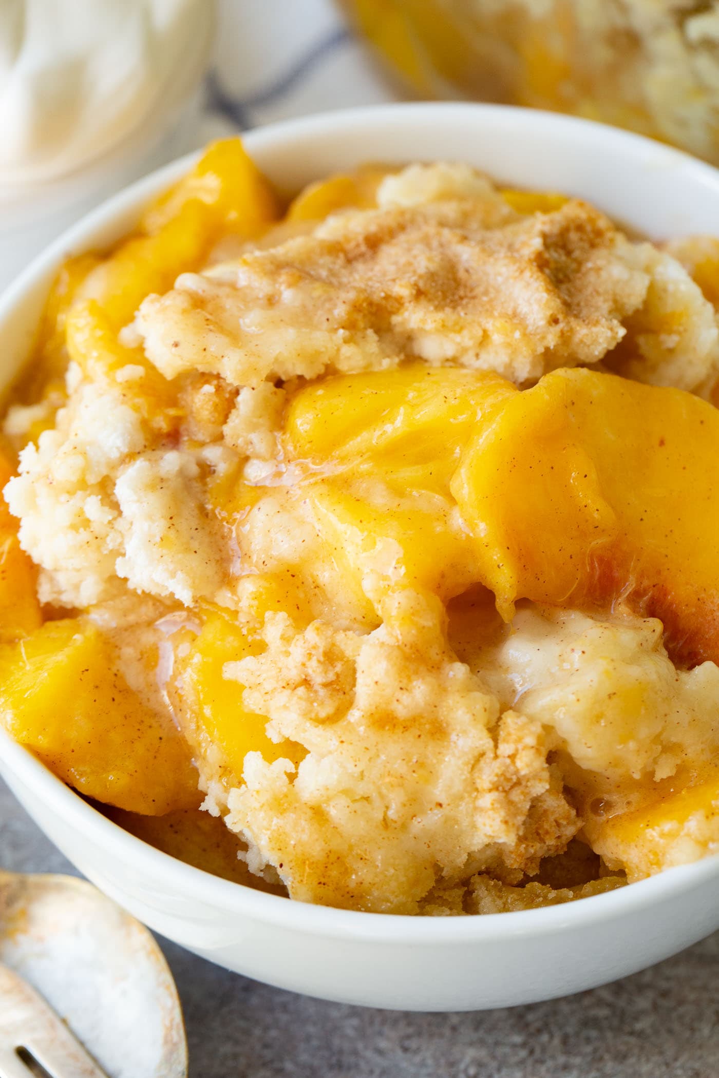 a bowl of instant pot peach cobbler with cake mix topping