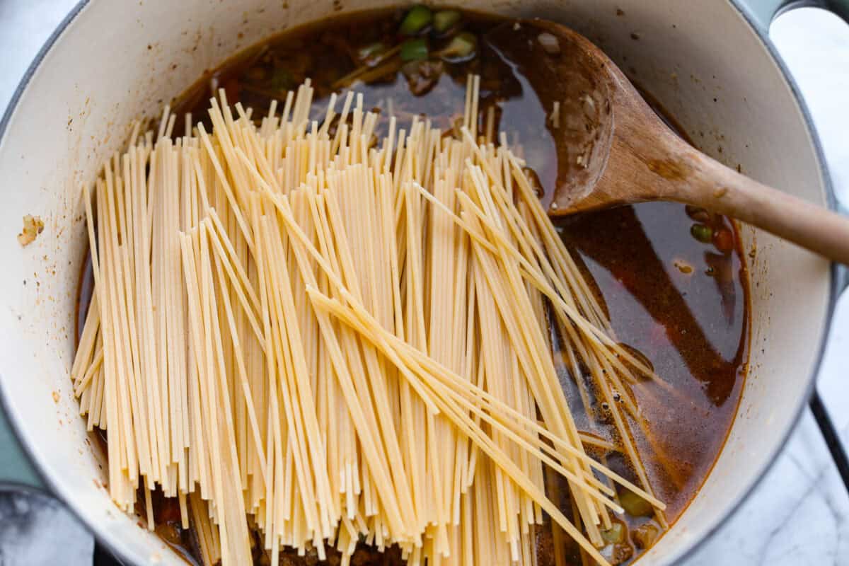 Beef broth and dry pasta added to the veggies and ground beef.