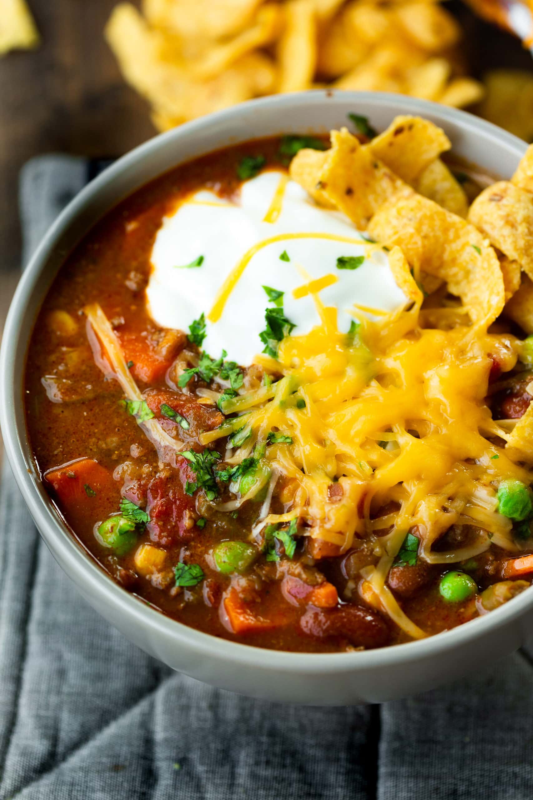 a photo of a bowl of taco stew topped with a dollop of sour cream, a pile of shredded cheddar cheese and a few Fritos chips. a photo of a bowl of taco stew topped with a dollop of sour cream, a pile of shredded cheddar cheese and a few Fritos chips.