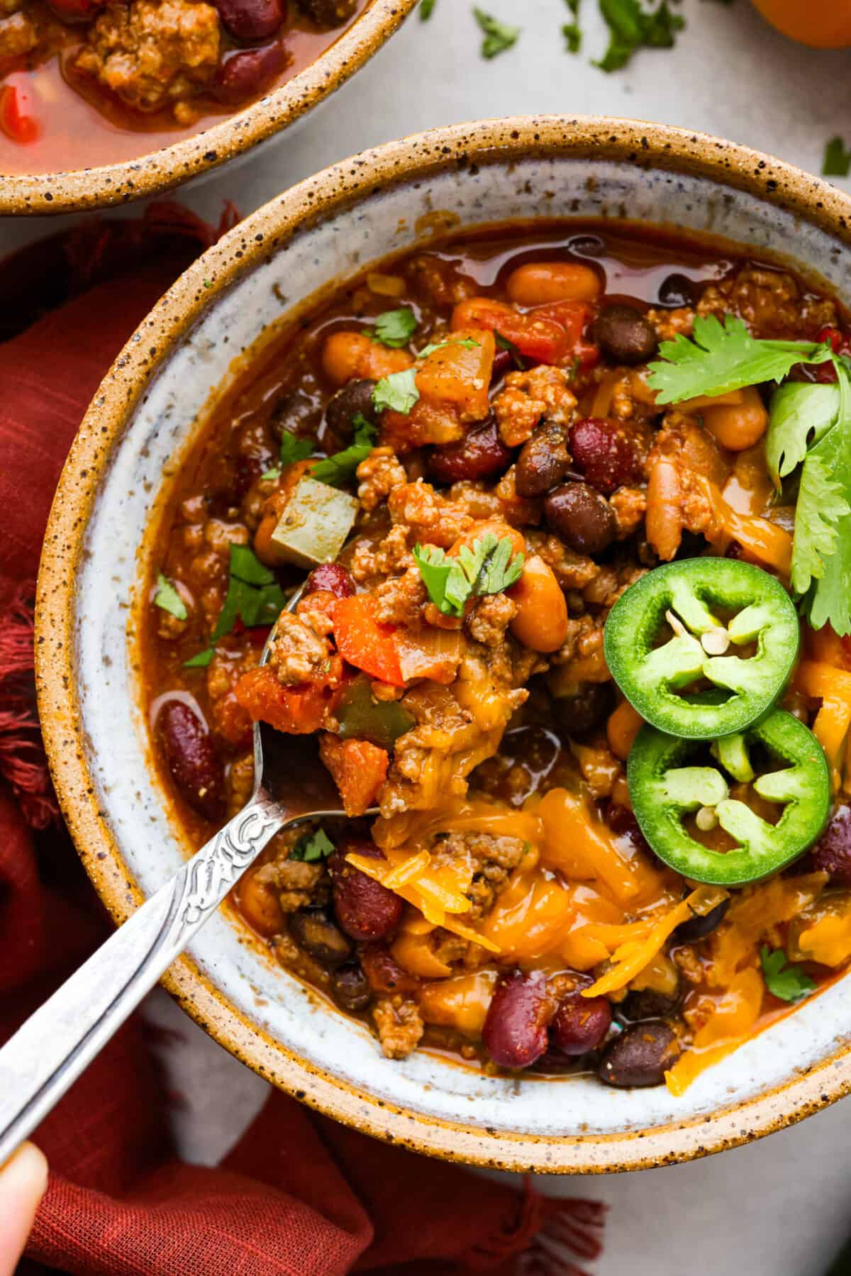 Closeup of the stew, topped with cheese and jalapenos.