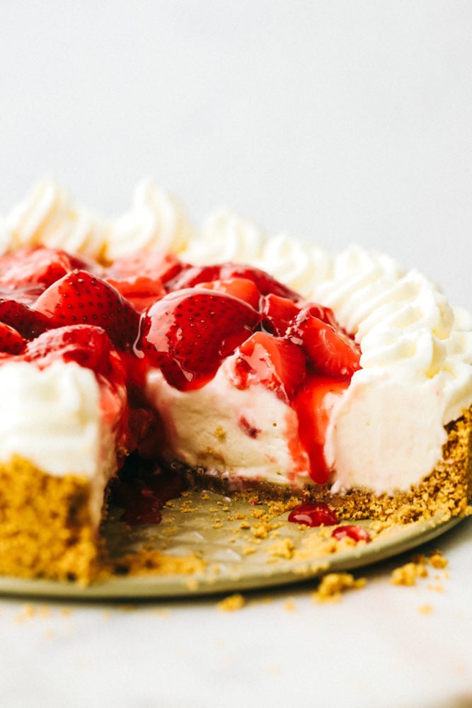 Close up on a no bake cheesecake with one slice missing.