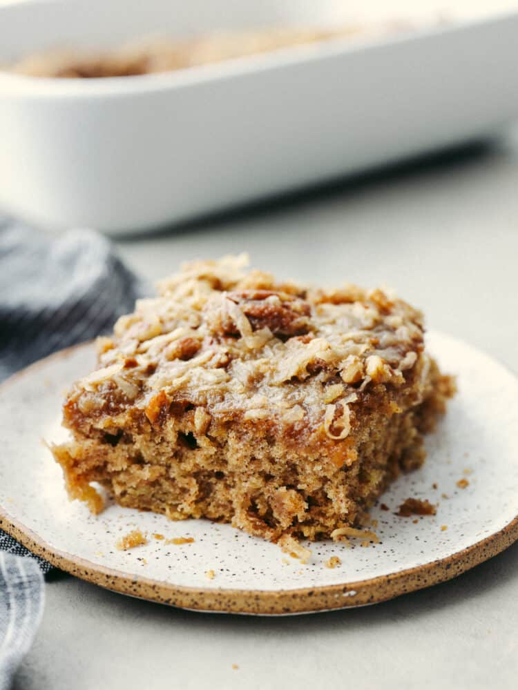 A square of oatmeal cake on a white, speckled plate. 